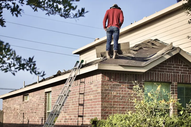 Professional roofer working on a residential roof in Stampede